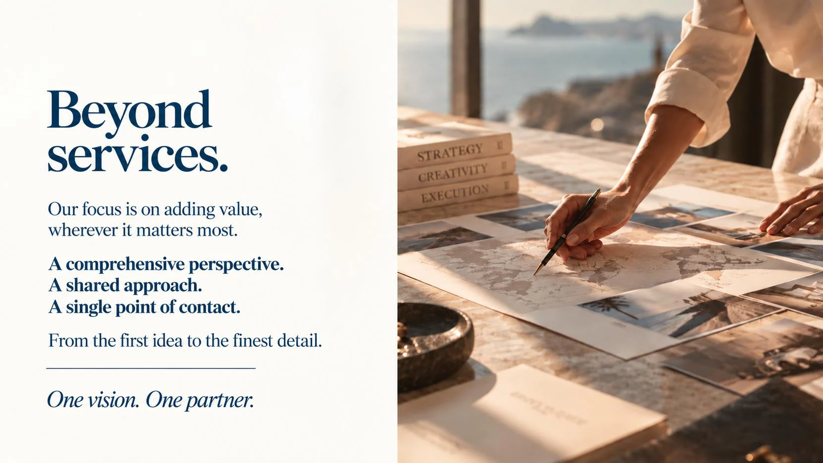 Desk with maps, photographs and books on strategy, creativity and execution, with the sea in the background.